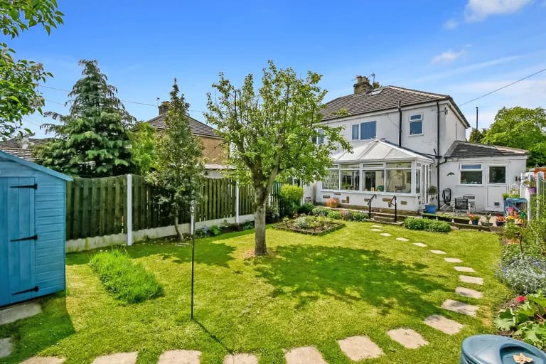 The garden features a large lawn, tile paved path, patio sitting area and garden shed.