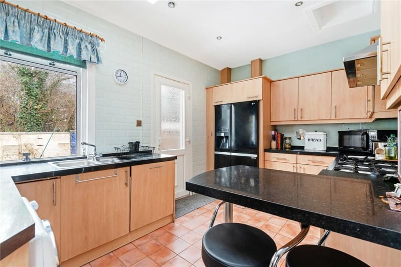 The kitchen area is fully fitted with a range of appliances and also features a breakfast bar. 