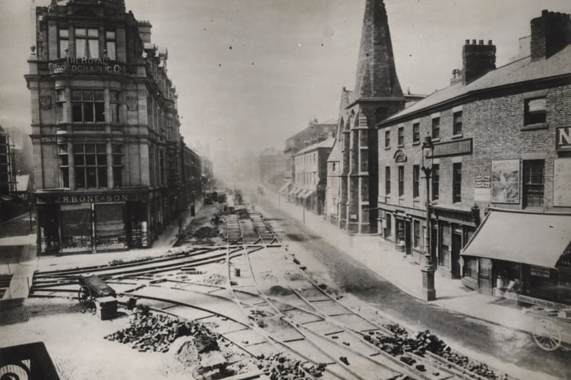 A view of Blackett Street taken in 1901. The photograph shows the laying of electric tram lines at the junction of Blackett Street and Grainger Street. In the centre left is 'The Royal Photographic Co.' building with 'J.R. Bone'.