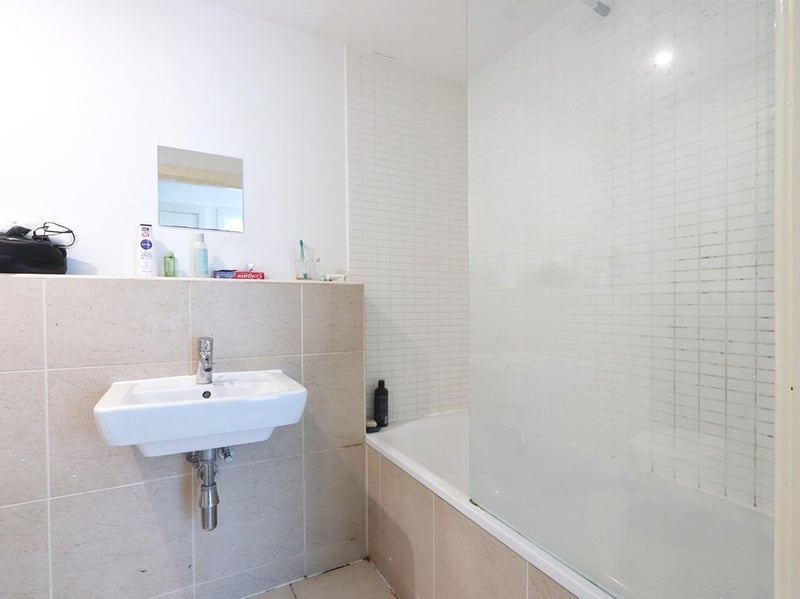 PIcture shows the basin, bath and shower in the bathroom