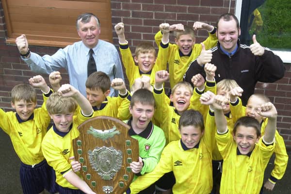 Meadowhall Junior School's football team with the Rotherham Junior School Cup trophy. Pictured with the boys are Malcolm Rhodes (left) and Richard Pease (right), who coach and manage the team.