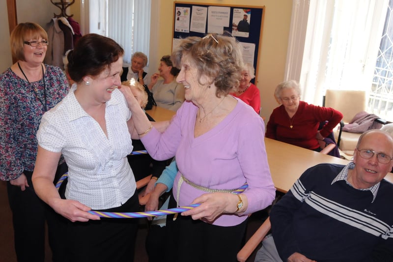 Drama teacher Lesley McDonough (left) and Lilian Stevenson 83, have fun with a hula hoop during a reminiscence theatre at Age UK in 2012.