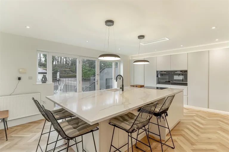 On the upper ground floor is a modern open dining kitchen with large central island.