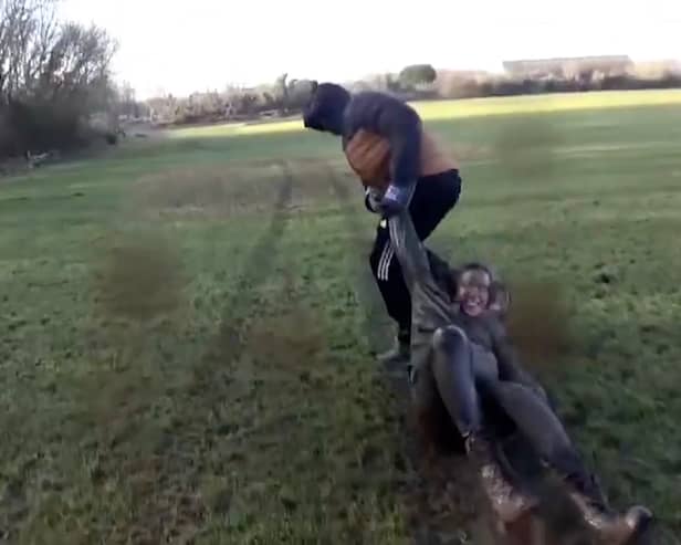 Masked 'steward' drags one of the women protesters through a muddy field during a hunt meeting. 
