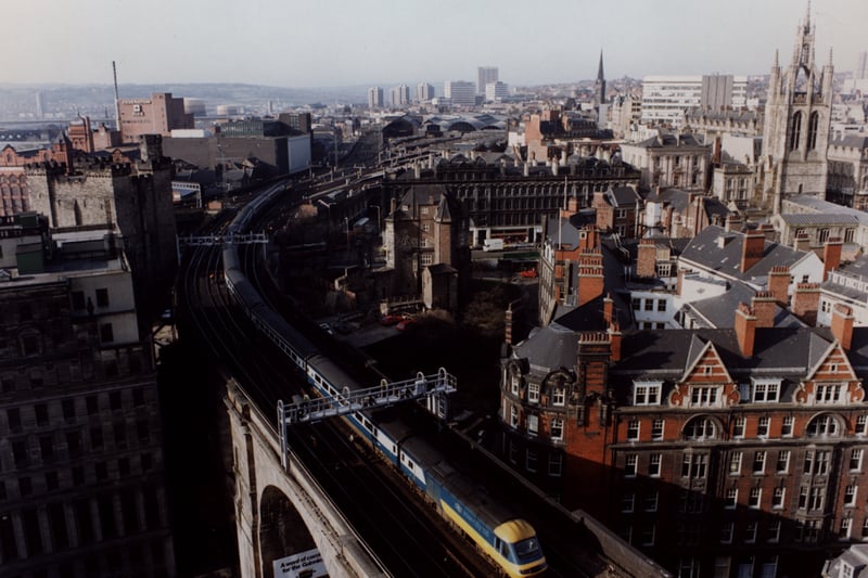 A bird's eye view of Newcastle upon Tyne taken in 1990. The railway bridge is in the foreground leading to the Central Station. Buildings on Dean Street are in the foreground to the left and the right. The Black Gate and the Keep are in the centre to the left and the right. The tower of St. Nicholas Cathedral is to the right of the Black Gate.