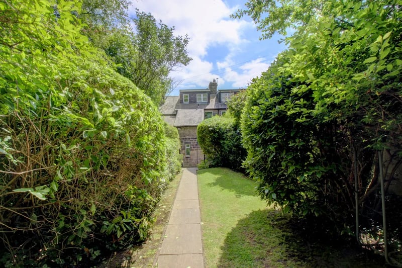 Extensive green gardens are located to the front and rear of the property.