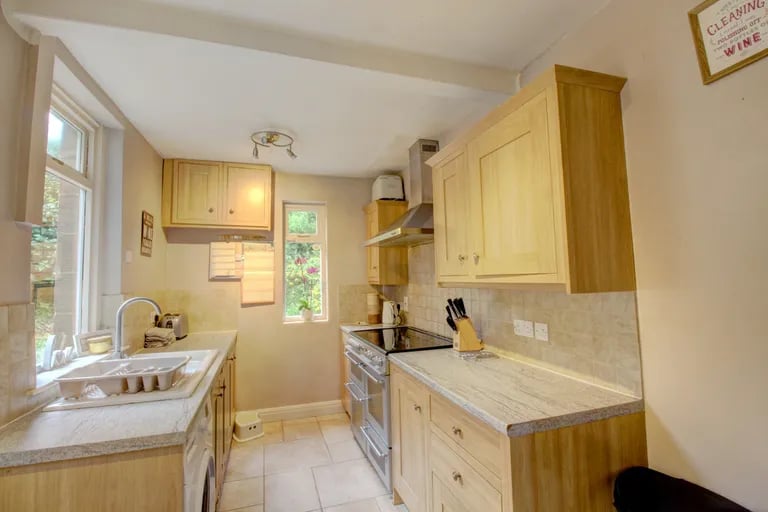 To the rear is the kitchen with fitted units and appliances, and access to the rear garden.