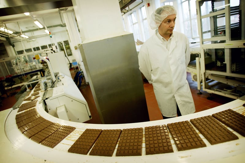 A Cadbury's factory worker checks all the chocolate on the production line in 2005 as the company celebrates 100 years of manufacturing at Bournville 