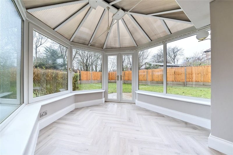 The bright conservatory offers a panoramic view of the enclosed rear garden.