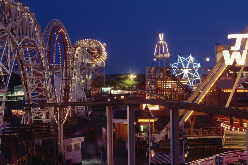 A night view of the illuminated rollercoaster and fun rides, 1983