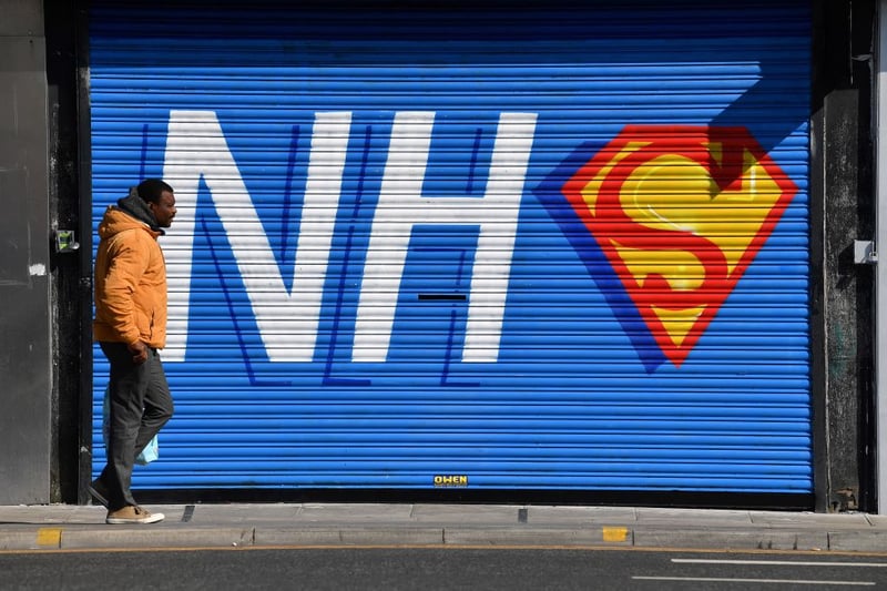 This graffiti depicting the NHS logo merged with the Superman emblem was daubed on the shuttered entrance of a closed pizza restaurant during the Covid-19 lockdown in 2020.