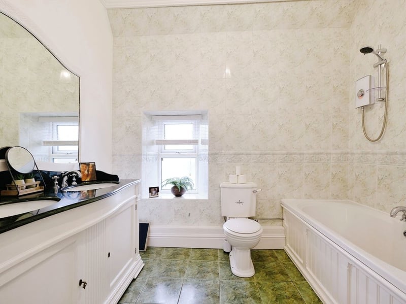 The family bathroom features a bath, two sink basins, a loo and storage. (Photo courtesy of Zoopla)