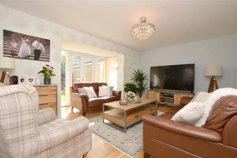It has two reception rooms, including this large living room with access to the rear garden.