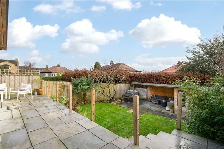 It overlooks an enclosed garden with lawn.