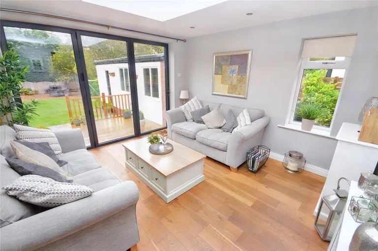 The sitting room with skylight above has bi-folding doors leading to a decked garden area.