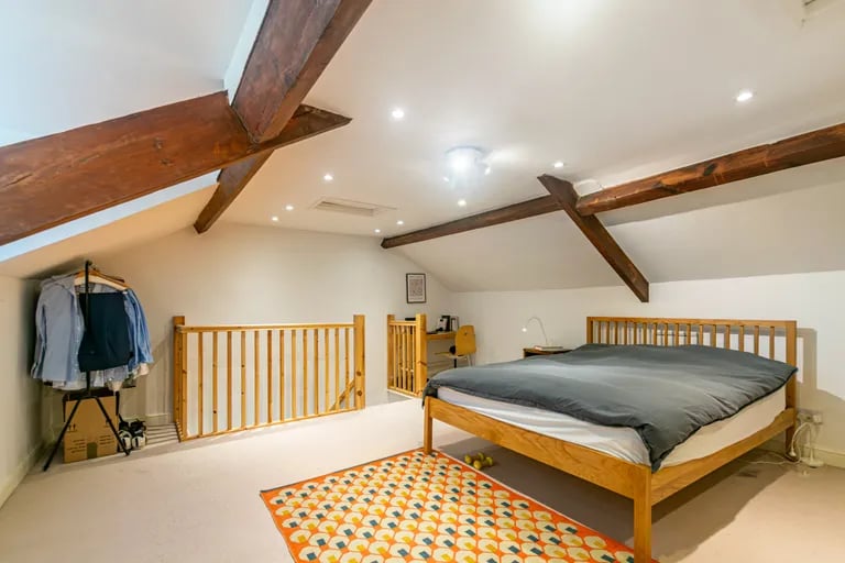 The loft bedroom features stunning exposed beams in the ceiling.