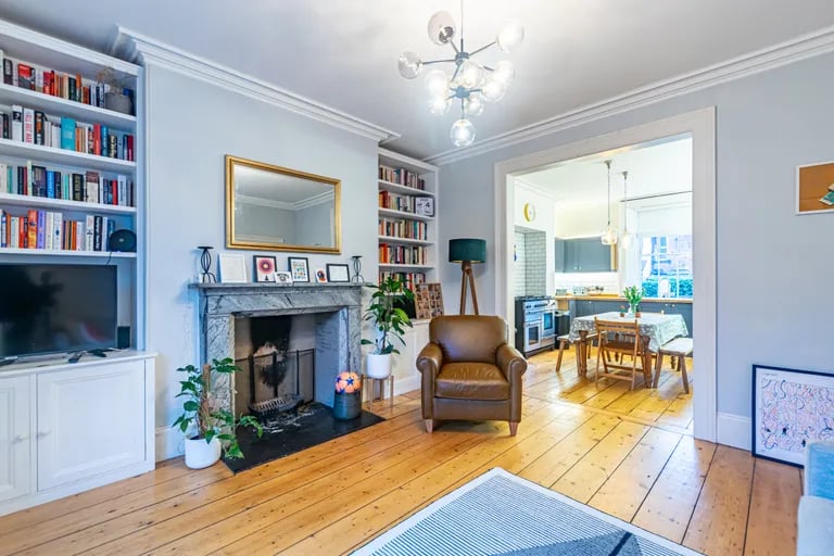 The lounge with wood floors leads to the dining kitchen.