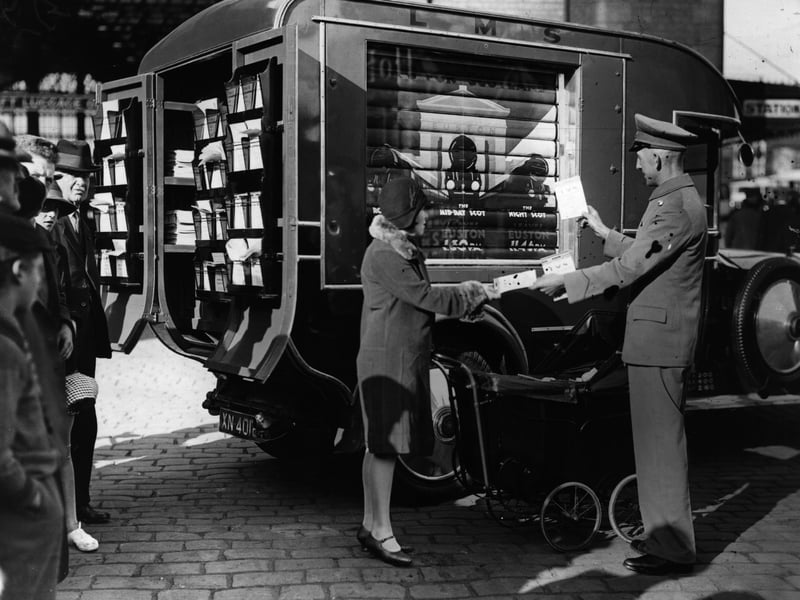 A woman receives information leaflets about holidays from a publicity van belonging to the London Midland and Scottish Railway Company, Blackpool