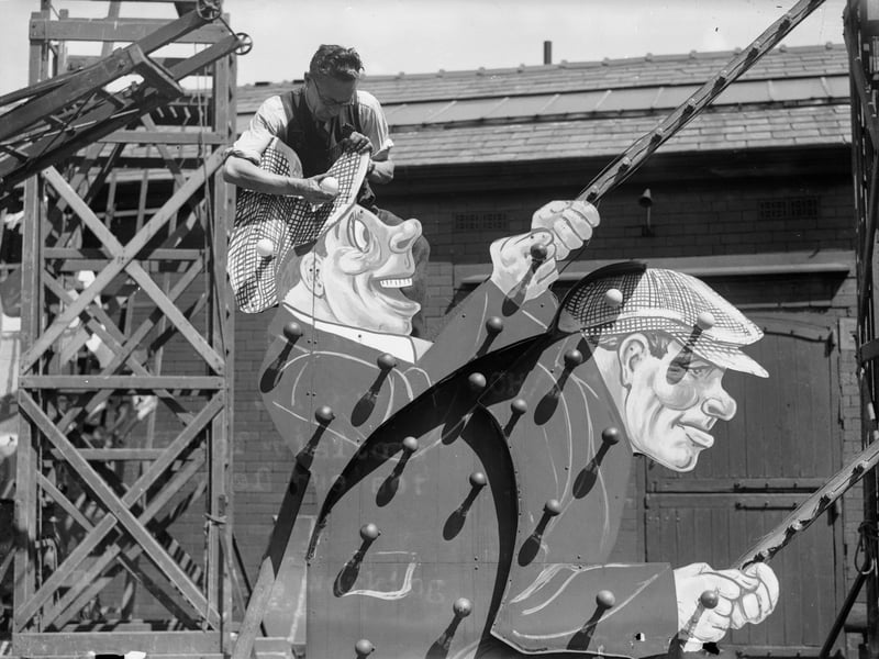 7th August 1936:  A workman fitting light bulbs onto an elaborate model which forms part of the Blackpool illuminations.  (Photo by Nick Yapp/Fox Photos/Getty Images)