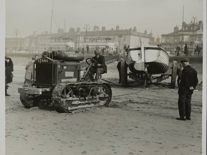 End of the season deck-chairs and ice-cream cabins were moved from the beach at Blackpool. A final sign which gave the end of the summer season was the removal of the fishing and pleasure boats from the beach. This work was done with the use of a tractor. This picture shows a tractor pulling in one of the motor boats, Blackpoo