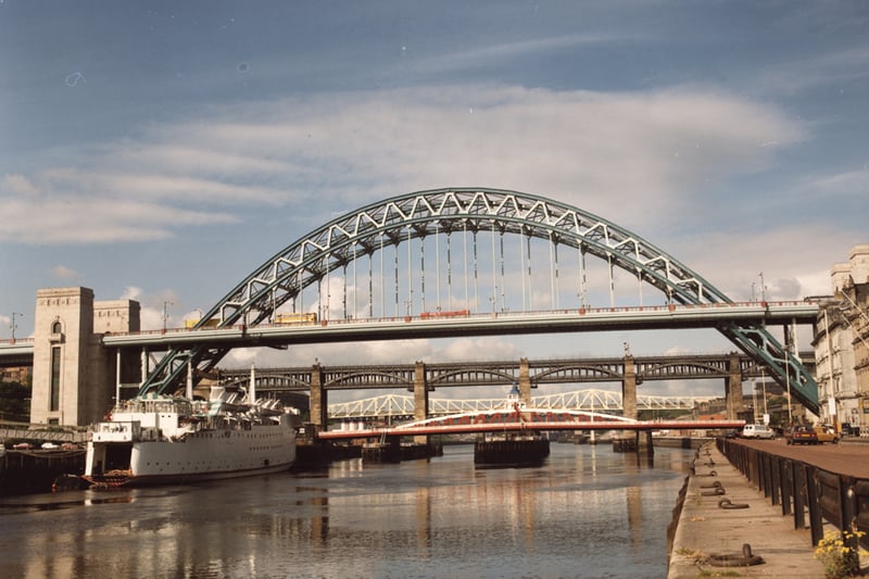 A 1985 photograph of the Newcastle bridges taken from Newcastle. The view is looking up the river towards the four bridges. The Tuxedo Princess is in the foreground to the left moored against the Gateshead Quayside. 