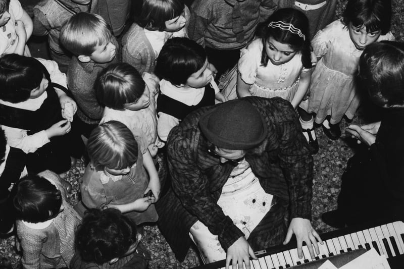 12th November 1938:  Children rehearsing for a Blackpool pantomime gathered round the piano player.  (Photo by Fox Photos/Getty Images)