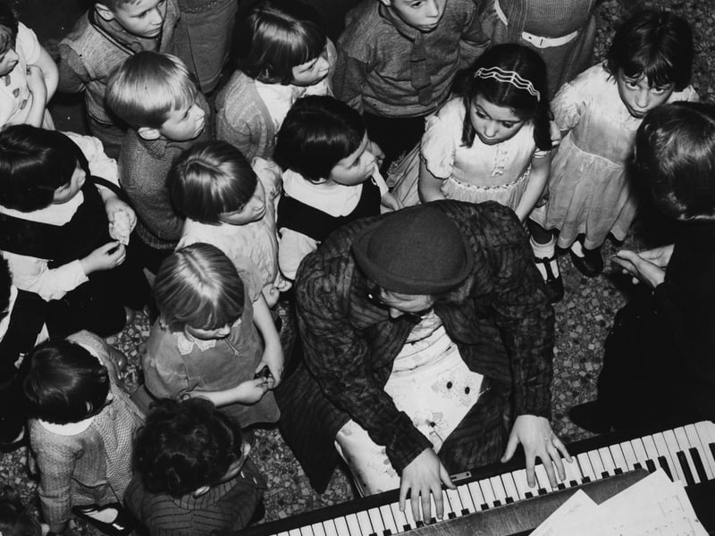 12th November 1938: Children rehearsing for a Blackpool pantomime gathered round the piano player. (Photo by Fox Photos/Getty Images)