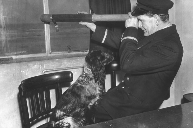 30th November 1939:  The coxswain of the Blackpool lifeboat, W R Parr, looking out to sea while his dog watches him.  (Photo by B. Marshall/Fox Photos/Getty Images)