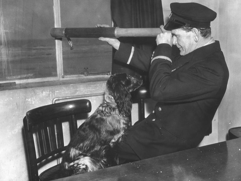 30th November 1939: The coxswain of the Blackpool lifeboat, W R Parr, looking out to sea while his dog watches him. (Photo by B. Marshall/Fox Photos/Getty Images)