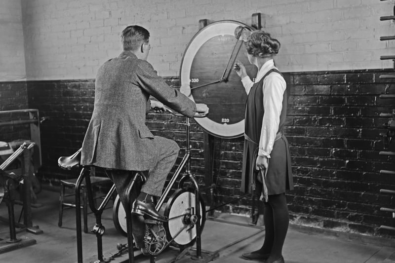 A man accompanied by a female instructor as he rides a machine for strengthening leg muscles. The gauge on the wall possibly measuring resistance, at the training centre for disabled soldiers in Blackpool, Lancashire, England, 20th February 1920. (Photo by Thompson/Topical Press Agency/Hulton Archive/Getty Images)