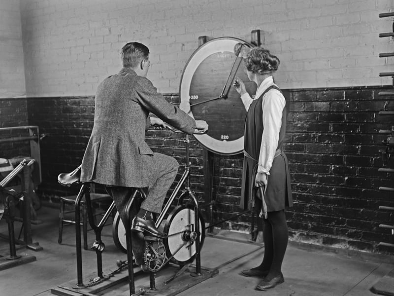 A man accompanied by a female instructor as he rides a machine for strengthening leg muscles. The gauge on the wall possibly measuring resistance, at the training centre for disabled soldiers in Blackpool, Lancashire, England, 20th February 1920. (Photo by Thompson/Topical Press Agency/Hulton Archive/Getty Images)