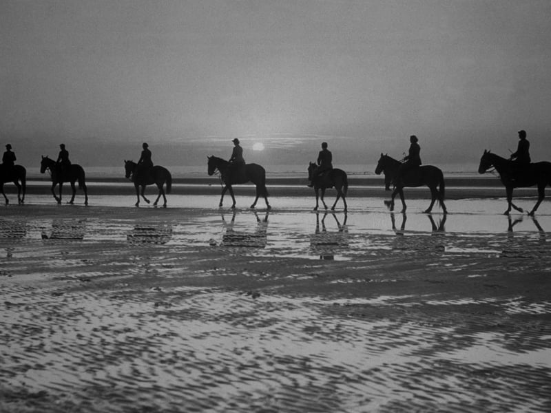 circa 1937: Horse riders on Blackpool beach, silhouetted against the evening sky. (Photo by Fox Photos/Getty Images)