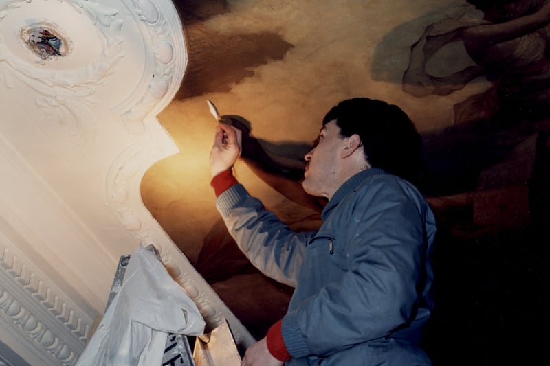  A photograph of an artist painting a mural onto the ceiling of the Theatre Royal in 1987.