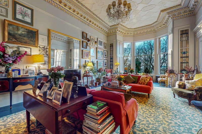 The drawing room is generous in size and features  ornate gold leaf cornicing. 