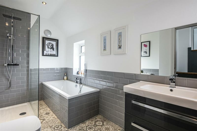 The family bathroom has a white suite with a separate shower enclosure. The bath and walls are tiled in a stylish grey.