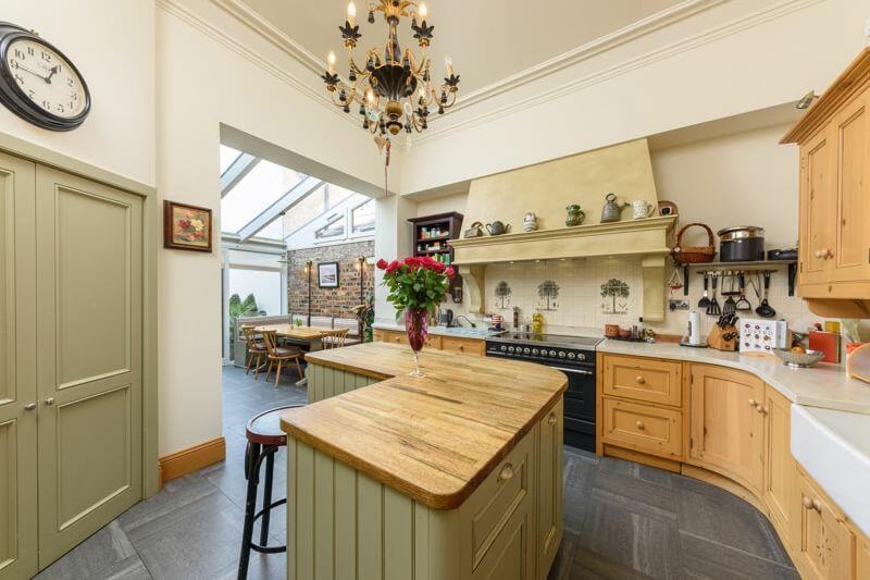 The spacious kitchen features an island and a range cooker and a walk-in larder.
