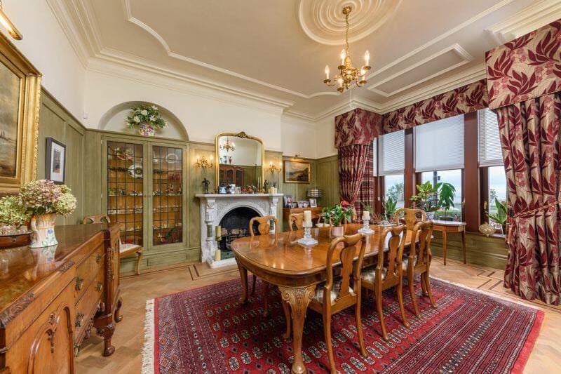 The dining room comes complete with a marble fireplace and impressive display cabinets.