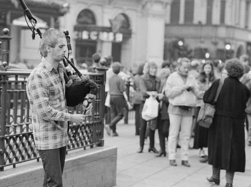 A piper playing the bagpipes as he busks near Piccadilly Circus underground station in London, England, United Kingdom, in December 1995. (Photo by Steve Eason/Getty Images)