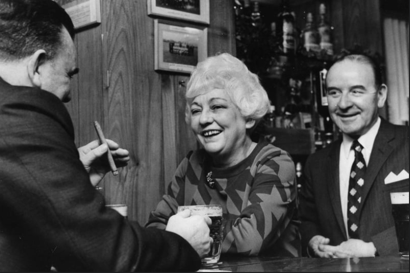 Edith Coulson, manageress of Albermale public house chatting to customers in January 1971.