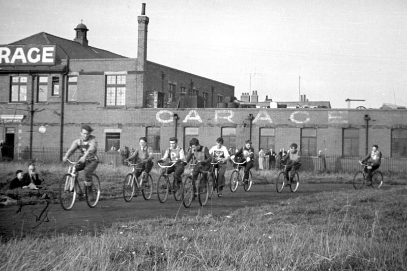The parade of riders in the 1952 North West Fylde League individual championship 1952. 
Riders from left: Derek Bowker (Marton Monarchs), Peter Earnshaw (Bispham), Fred O'Donnell (Bispham), John Perkins (Bispham), Fred Warwick (Broadway Fleetwood), Keith Bailey (Bispham), David Thorpe (Bispham) and Ray Marshall (Bispham). The scene is the Marton Flyers track on land off Waterloo Road. The building in the rear is Gradwell's Garage