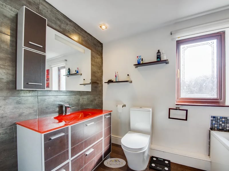 The first floor bathroom features a lot of storage around the sink as well as a shower/bath. (Photo courtesy of Zoopla)