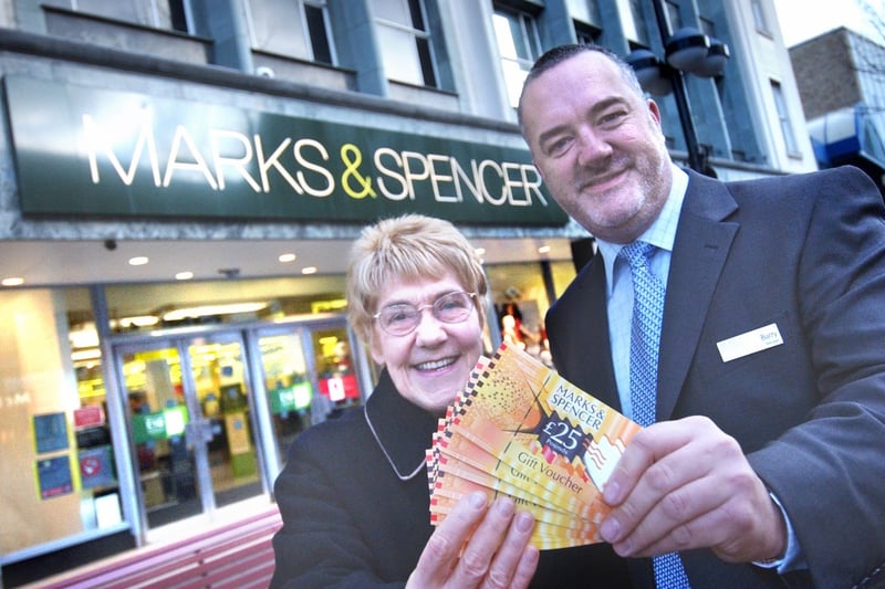 Store manager Barry Bailes presented Marcia Walsh with vouchers after she won them in a competition in 2009.