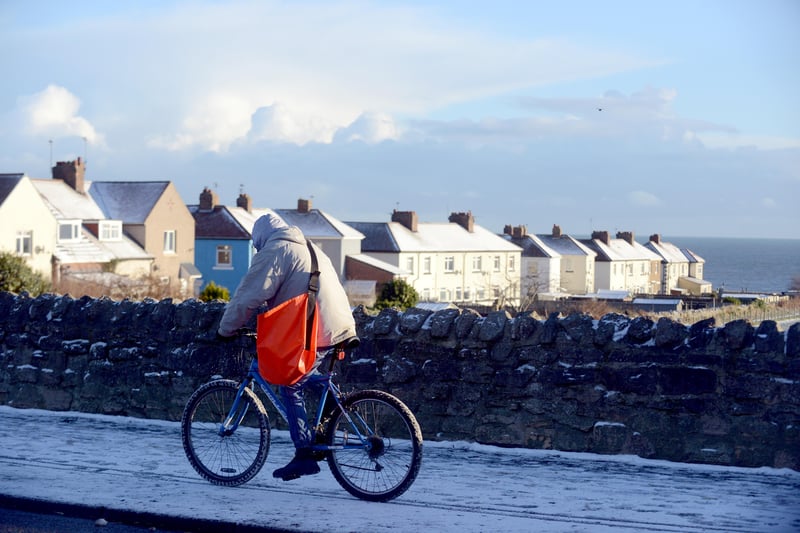 A cyclist braving the snowy conditions to deliver the morning newspapers.