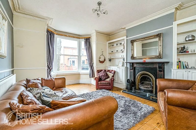 A welcoming and generously sized living area with a bay window, offering ample natural light with a cosy fireplace