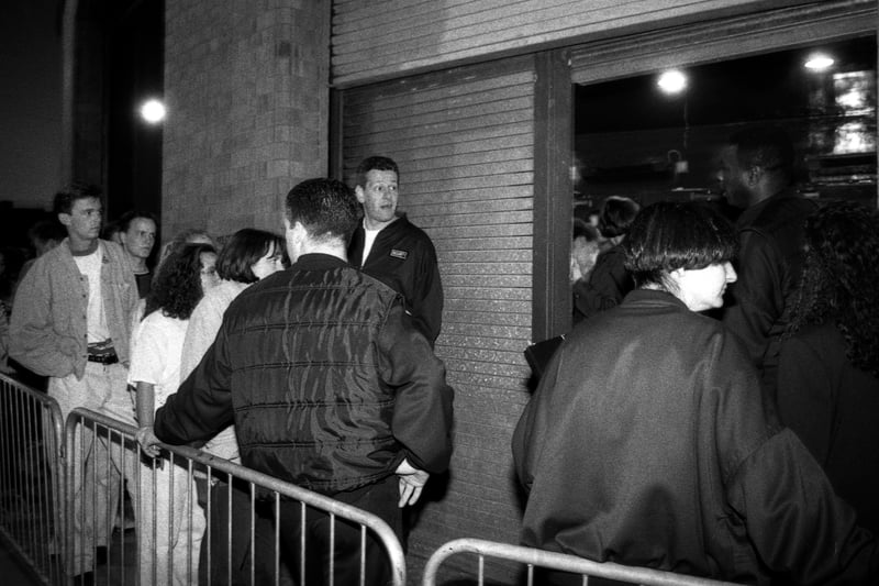 Clubbers wait as the queue for the Hacienda grows longer. On the right people are let in on the guest list