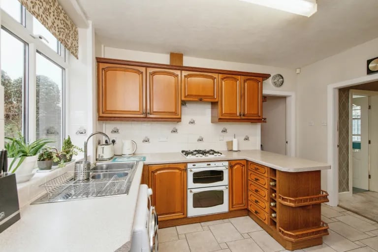 A stylish kitchen with lots of workspace sits to the back of the property with access to the garden and adjacent garage.