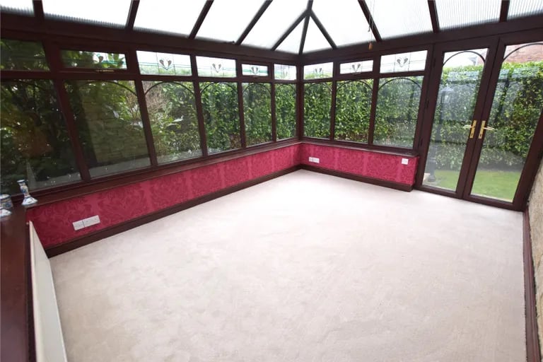 The spacious conservatory has a panoramic view of the garden, which can be accessed via French doors.