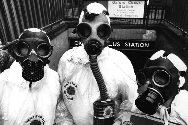 Members of environmental pressure group Friends Of The Earth, dressed in gas masks and protective clothing, handing out anti-nuclear material at an entrance to Oxford Circus underground station, London.  (Photo by Evening Standard/Getty Images)