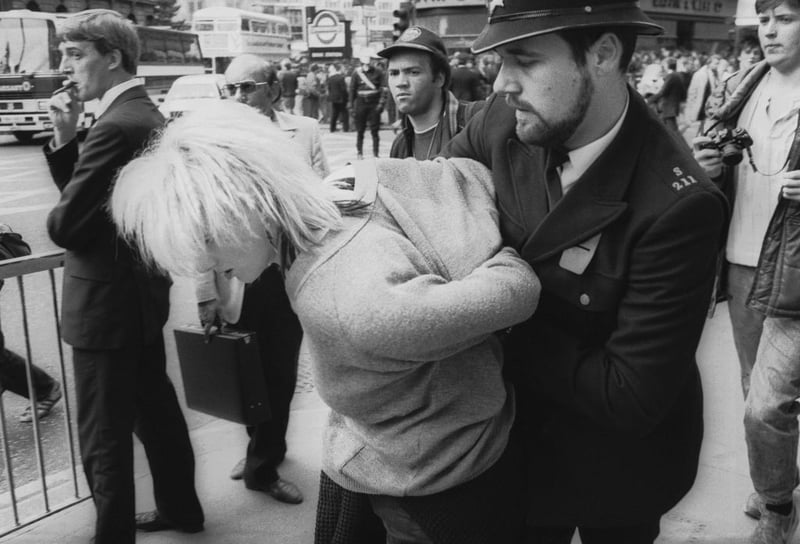 A City of London Police officer arrests a young woman outside Bank Underground Station during a 'Stop The City' anti-capitalist demonstration, London, September 1984. (Photo by Steve Eason/Hulton Archive/Getty Images)