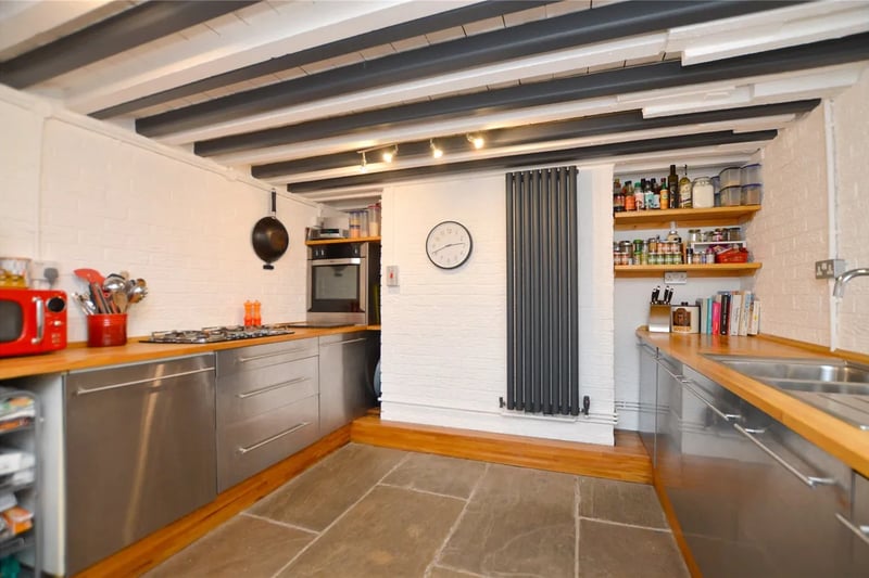 On the bottom floor is a stylish kitchen with a range of modern stainless steel units with solid wood work surfaces and Yorkshire stone flagged floor and sliding doors opening to the decked terrace to the rear sitting over the canal.